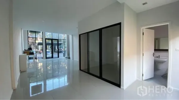 Retail Space for sale in Bang Na, Bangkok - Bright ground‑floor retail hall with floor‑to‑ceiling glass shopfront and glossy tile flooring.