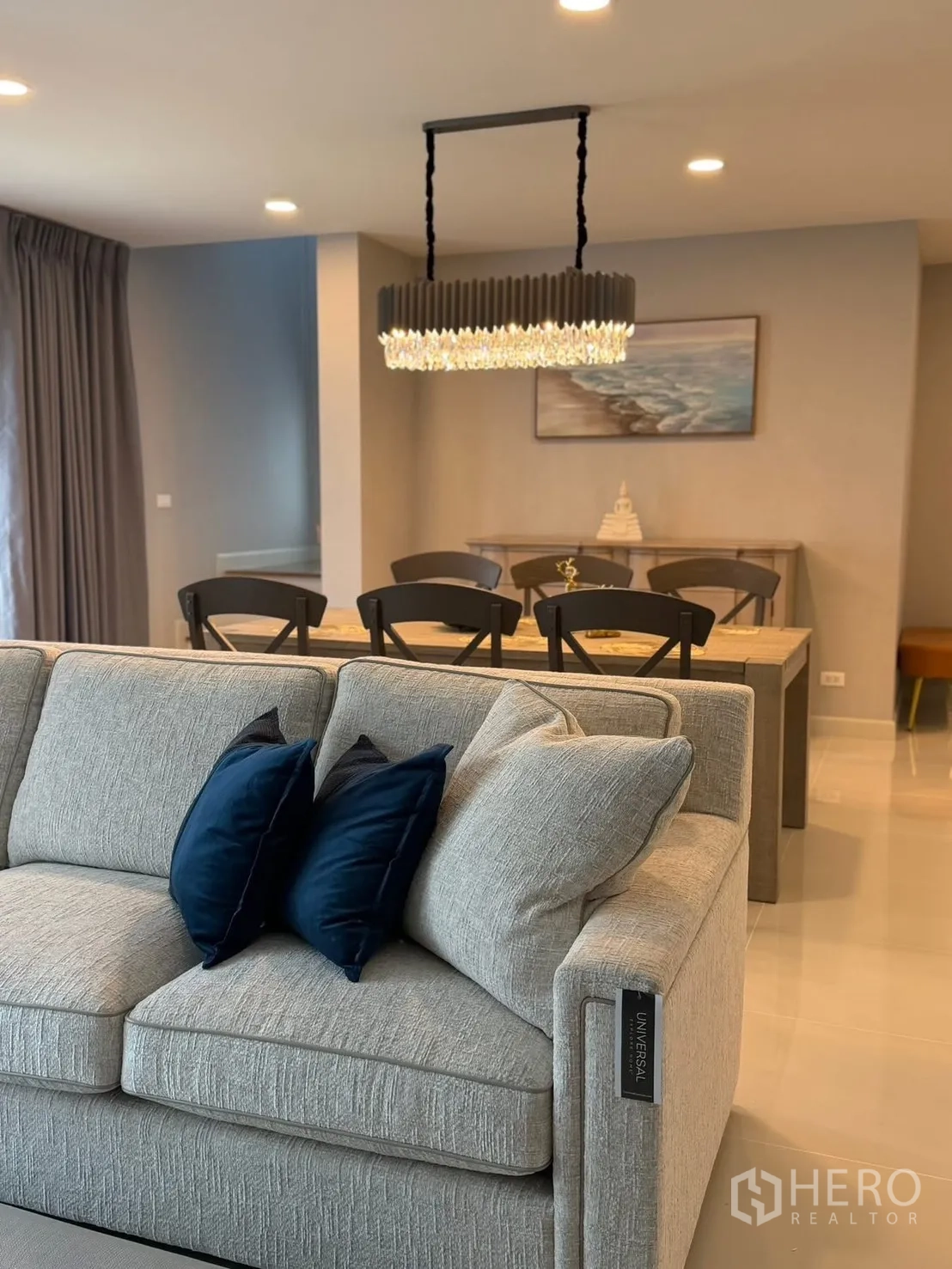 บ้านเดี่ยว for rent in Bang Phli, Samut Prakan - โถงนั่งเล่นและทานอาหารแบบโอเพ่นสเปซพร้อมโซฟาสีเทาอ่อนและโคมแขวน