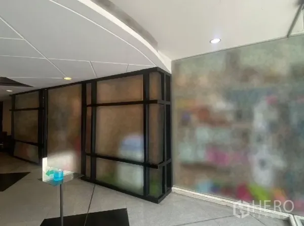พื้นที่ขายปลีก ให้เช่าในWatthana, Bangkok - มุมทางเดินภายใน กั้นกระจกกรอบสีดำและฝ้าโค้ง ใกล้ประตูทางเข้า