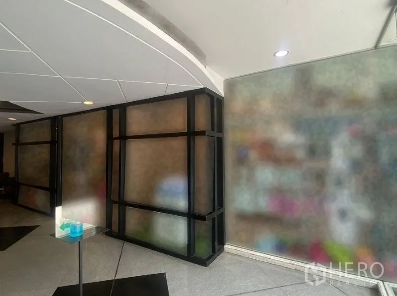 พื้นที่ขายปลีก ให้เช่าในWatthana, Bangkok - มุมทางเดินภายใน กั้นกระจกกรอบสีดำและฝ้าโค้ง ใกล้ประตูทางเข้า
