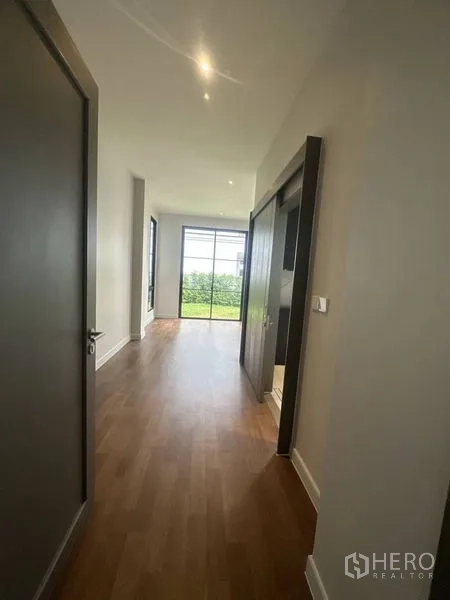 Detached House for rent - Bedroom corridor with wood floors, built-in wardrobe and a large garden-facing window.