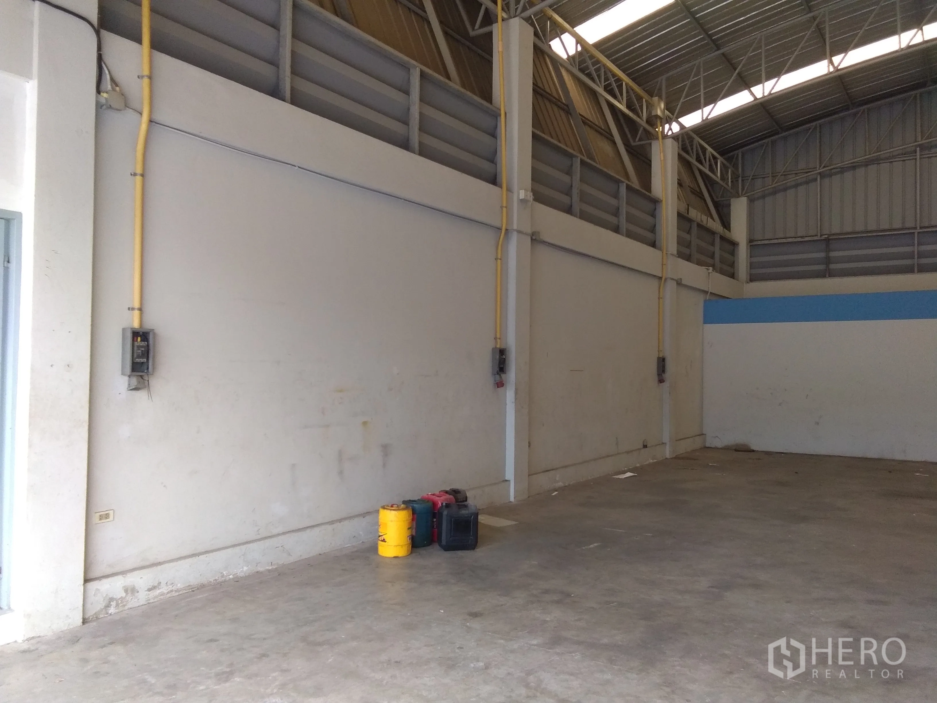 Factory for sale in Lam Luk Ka, Pathum Thani - High-ceiling factory floor with concrete slab, power points and a steel roof structure.