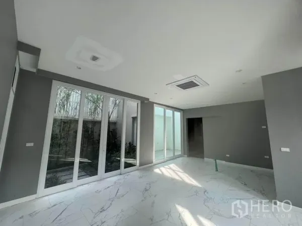 Detached House for sale in Yan Nawa, Bangkok - Bright family area with floor-to-ceiling sliding glass doors opening to a private courtyard.