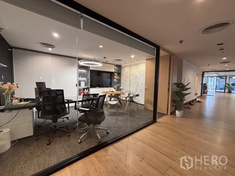 Office Space for rent in Bang Rak, Bangkok - Glass-enclosed office with workstations, a TV, shelving, and a whiteboard wall.