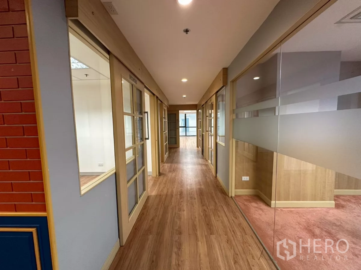 Office Space for rent in Khlong Toei, Bangkok - Bright corridor lined with glass partitions and wooden framed doors.