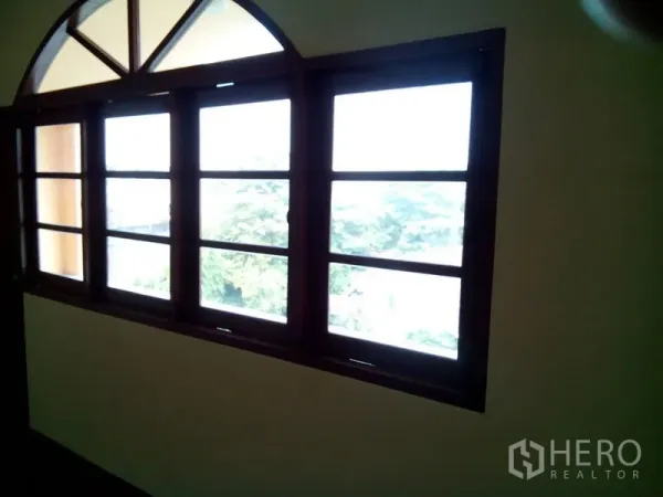 Shophouse for rent in Phra Khanong, Bangkok - Row of wooden-framed windows with arched transom bringing natural light.