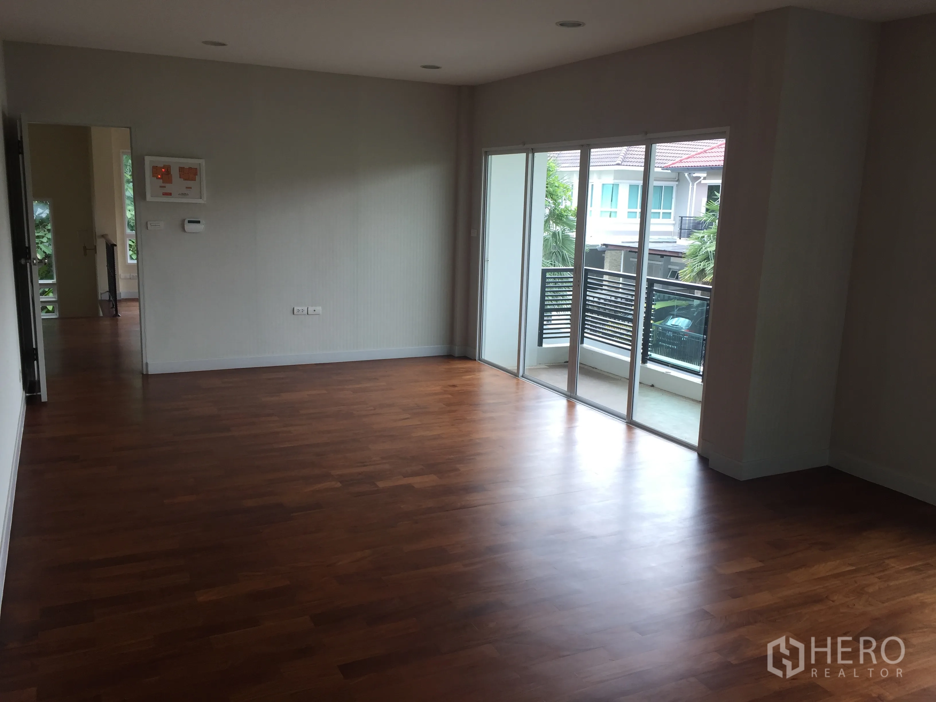 Detached House for sale in Saphan Sung, Bangkok - Secondary room with wood floors and sliding doors opening to a balcony.