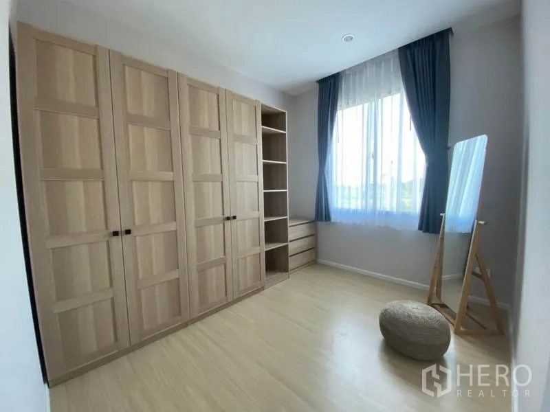 Townhouse for rent in Saphan Sung, Bangkok - Dressing room with full-height wardrobes, open shelves and a standing mirror by the window.