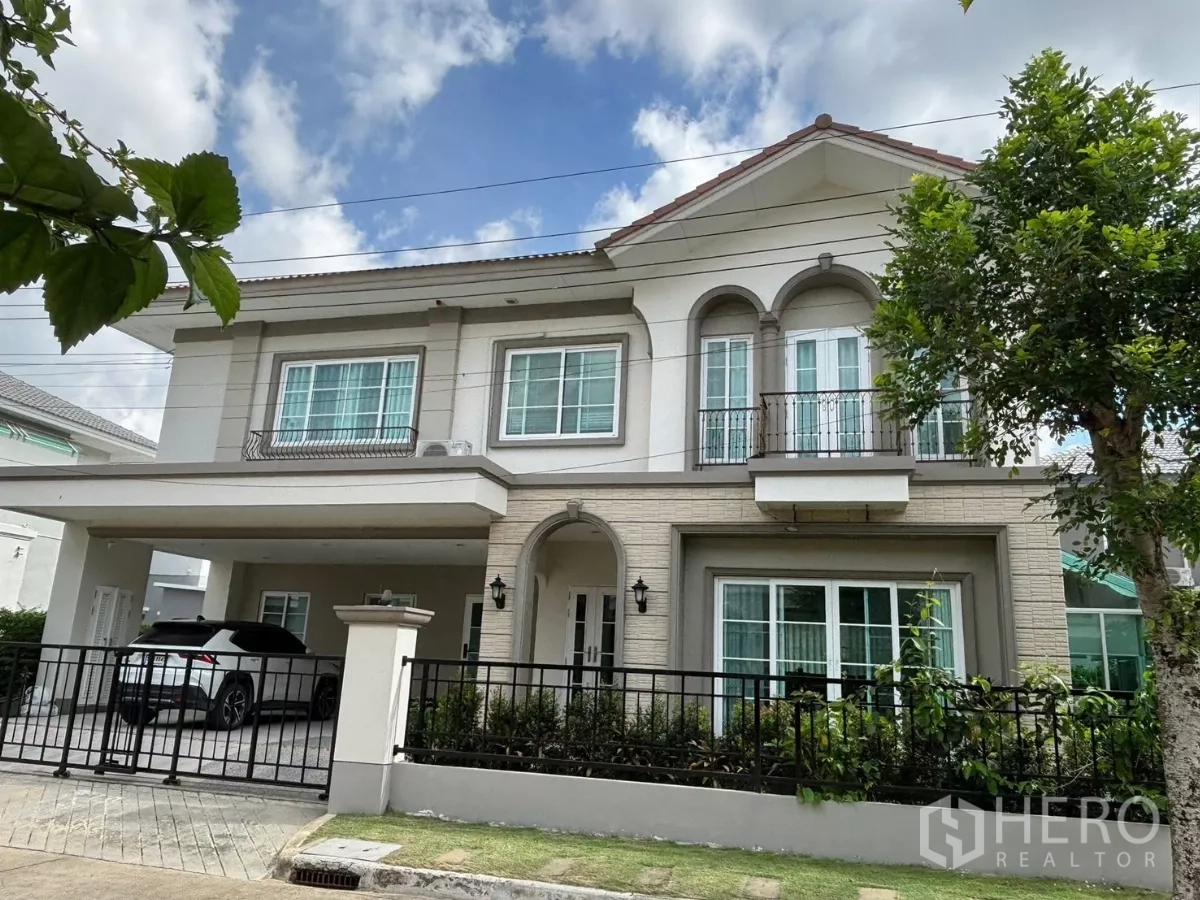 独立式住宅 出租在Prawet, Bangkok - 两层独栋别墅，带前院围栏、阳台与有顶车位，园景整洁。