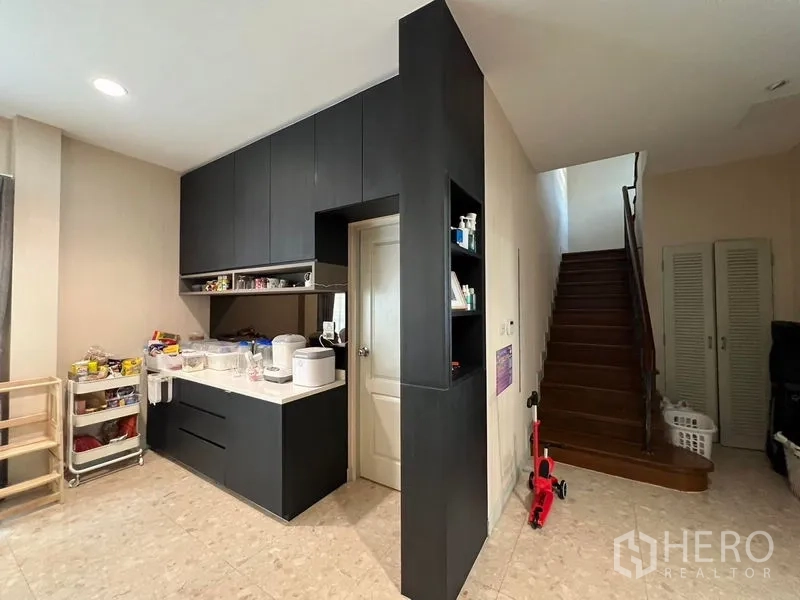 Detached House for rent or sale in Saphan Sung, Bangkok - Pantry and staircase with dark built-in cabinetry and storage.