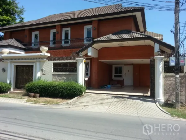Detached House for rent in Watthana, Bangkok - Street-facing facade of the house with tiled roof, gated entrance and covered carport.