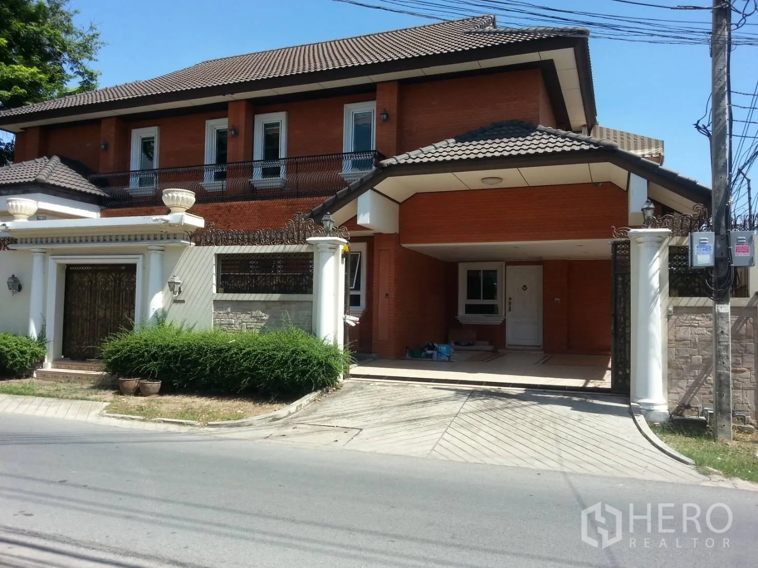 Detached House for rent in Watthana, Bangkok - Street-facing facade of the house with tiled roof, gated entrance and covered carport.