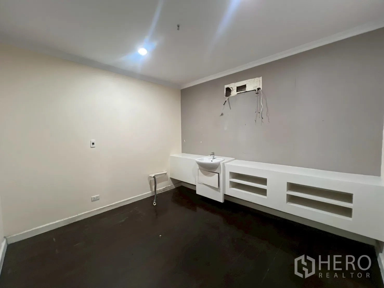 Office Space for rent in Watthana, Bangkok - Enclosed room with beige walls, dark floor and wall-mounted sink with utility ports.