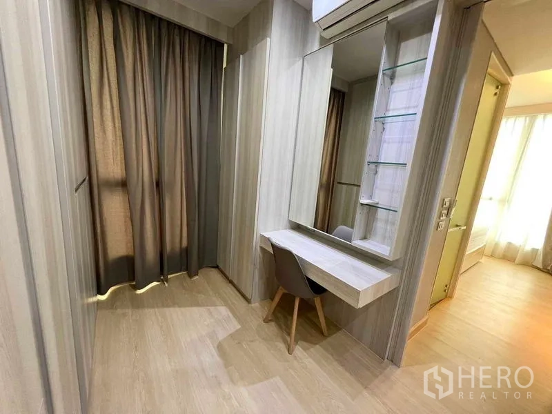 Condominium for rent or sale - Dressing area with wall mirror, floating vanity desk, and storage cabinets.
