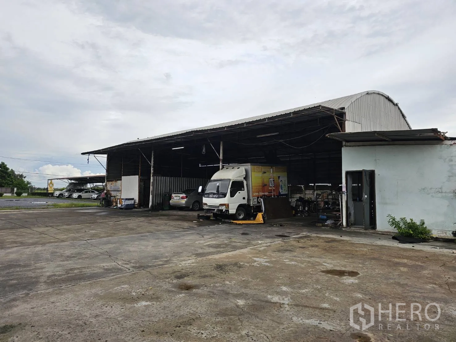 Warehouse for rent in Lam Luk Ka, Pathum Thani - Secondary shed with truck and car parked under open bays.
