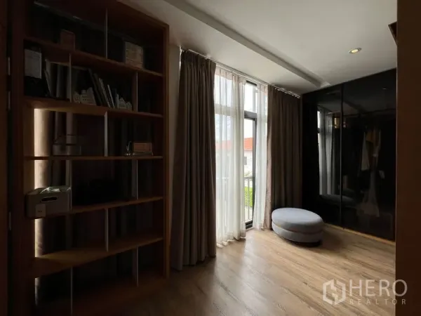 Townhouse for rent in Saphan Sung, Bangkok - Cozy study or dressing area with floor-to-ceiling curtains, built-in bookshelf, and ottoman.