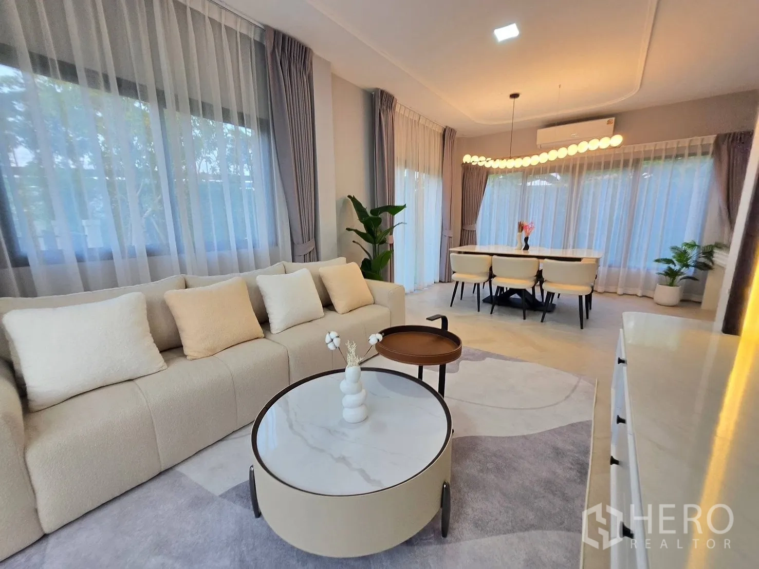 บ้าน for rent or sale in Bang Phli, Samut Prakan - โซนรับแขกและทานอาหารแบบโอเพ่นแพลน โซฟานุ่ม โต๊ะกลางทรงกลม และหน้าต่างกว้าง