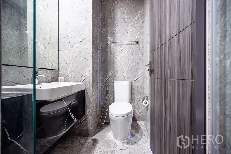 คอนโด ให้เช่าในWatthana, Bangkok - ห้องน้ำสมัยใหม่ ผนังลายหินอ่อนสีเทา โถสุขภัณฑ์ และอ่างล้างหน้า