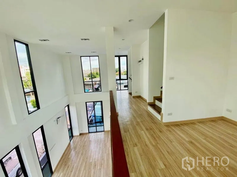 带办公室的家 出售在Wang Thonglang, Bangkok - 夹层俯瞰挑高大厅，大窗与楼梯相连