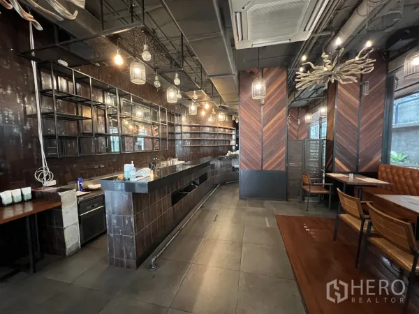 Retail Space for rent in Watthana, Bangkok - Long service bar with open shelving, industrial ceiling, pendant cage lights, and booth seating.