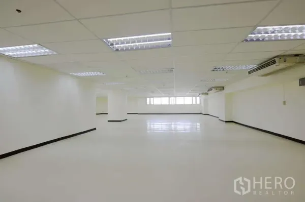 สำนักงาน ให้เช่า - พื้นที่ทำงานแบบเปิด มีฝ้าทีบาร์ ไฟสว่าง เครื่องปรับอากาศหลายตัว และพื้นเงา
