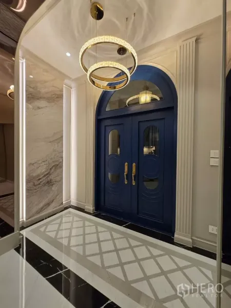 Detached House for rent or sale in Bang Kapi, Bangkok - Close-up of blue arched front doors with brass handles under circular chandeliers.