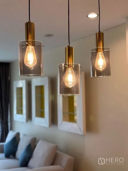 Condominium for rent in Bang Rak, Bangkok - Trio of contemporary pendant lights with exposed bulbs in the living space.