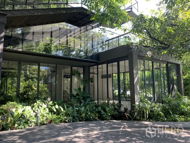 Office Space for rent in Khlong Toei, Bangkok - Two-storey glass-façade office pavilion surrounded by greenery with an upper terrace.
