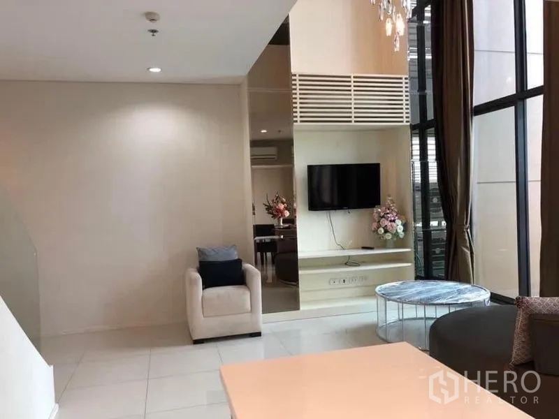 公寓 出租在Ratchathewi, Bangkok - 客厅高窗与电视墙，可通往阳台。