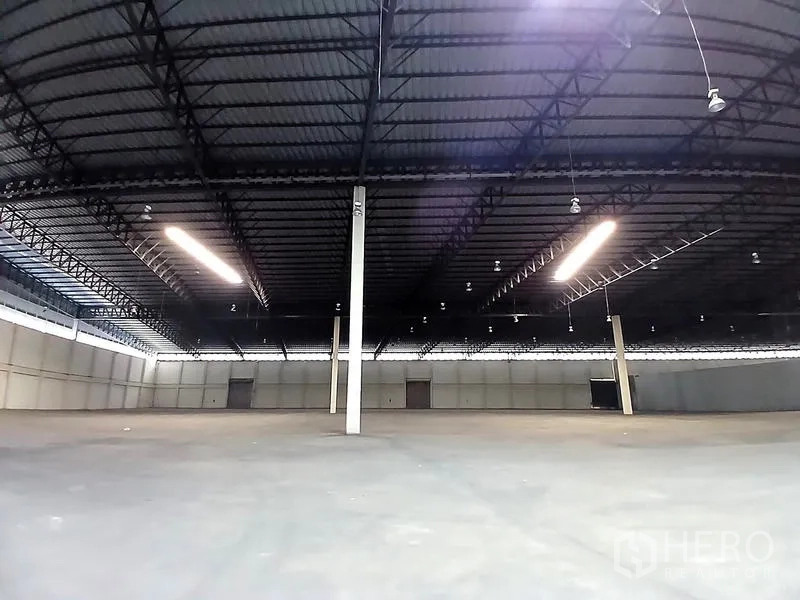 คลังสินค้า ให้เช่าในBang Pakong, Chachoengsao - ฮอลล์โกดังโล่ง โครงหลังคาเหล็ก ไฟแบบแถบสว่าง และประตูขนถ่ายสินค้า