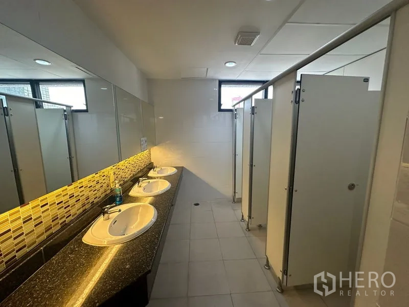Office Space for rent in Bang Rak, Bangkok - Well-lit washroom area with multiple sinks and private cubicles.