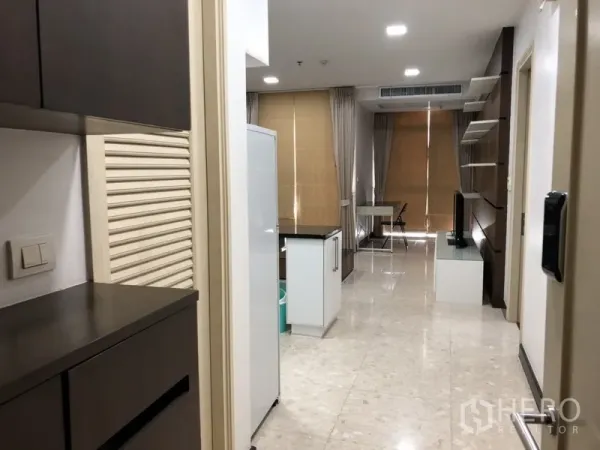 公寓 出租在Khlong Toei, Bangkok - 走廊通向开放式起居区，带岛台、落地窗与大理石地面。