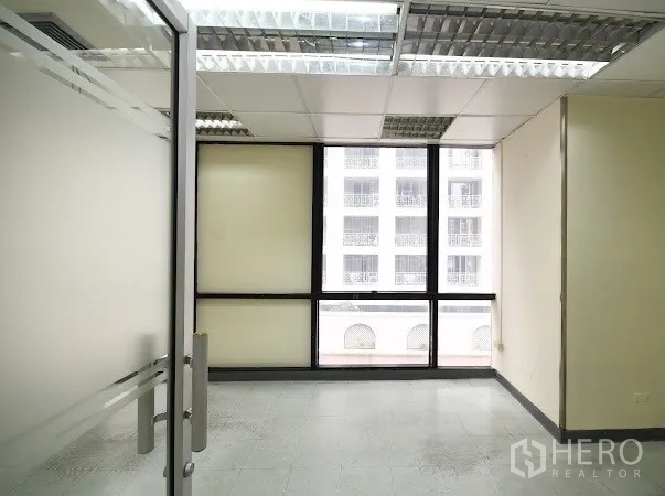 办公空间 出租在Watthana, Bangkok - 小型独立办公室，玻璃门和窗户，望向相邻建筑。
