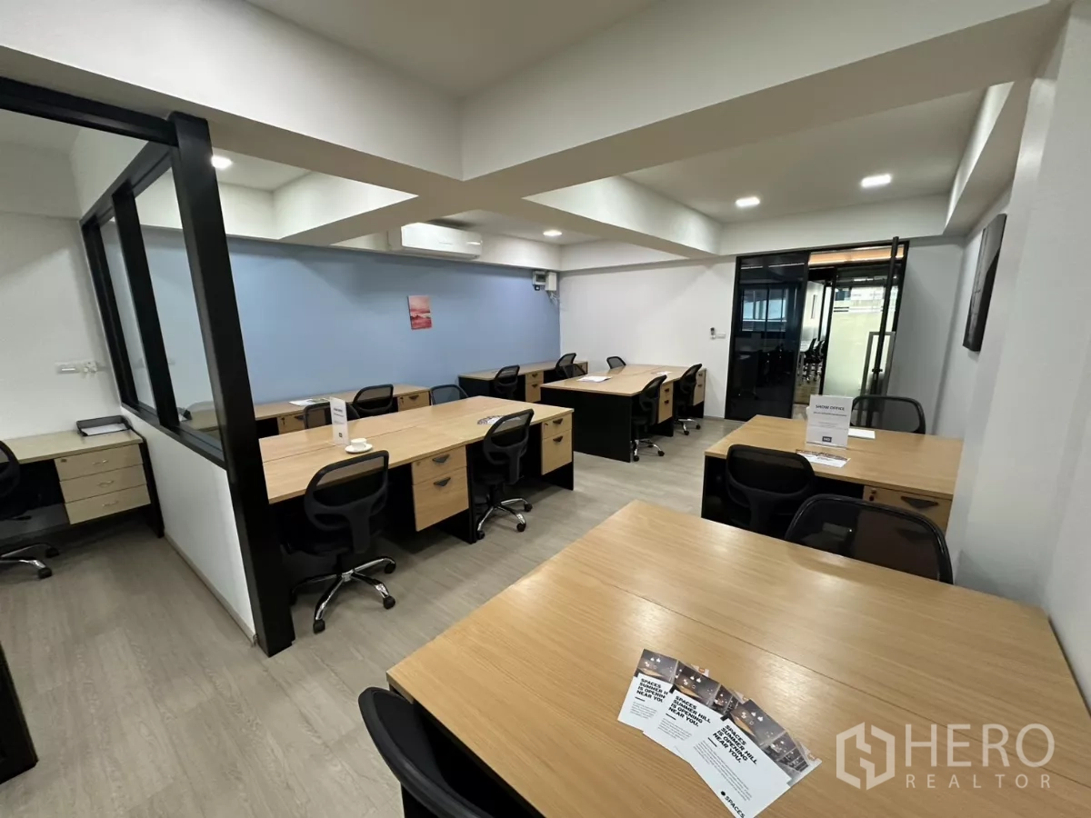 办公空间 出租在Watthana, Bangkok - 配家具的协作区，成组书桌，玻璃门通往会议室。