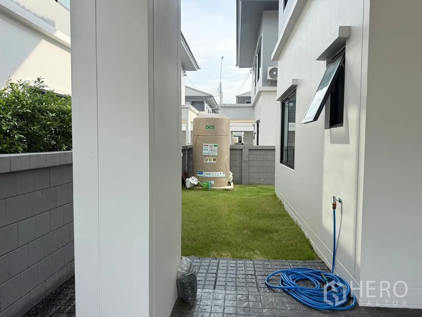 บ้านเดี่ยว for rent in Bang Phli, Samut Prakan - สนามหญ้าด้านข้างมีแท็งก์น้ำและก๊อกน้ำภายนอกติดกับตัวบ้าน.