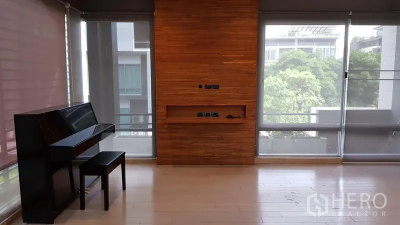 带办公室的家 出售在Wang Thonglang, Bangkok - 采光充足的起居空间，木质特色墙与落地窗