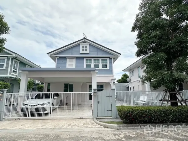 บ้าน ให้เช่าหรือขายในBang Phli, Samut Prakan - หน้าบ้านเดี่ยวสองชั้นโทนสีฟ้า มีรั้วและที่จอดรถในร่ม