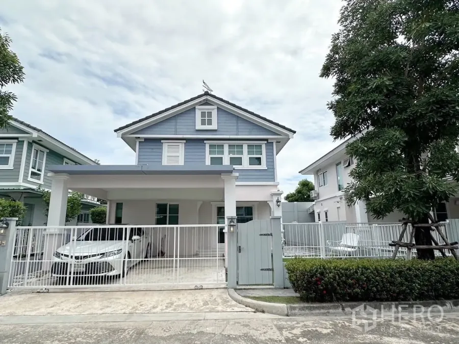 บ้าน ให้เช่าหรือขายในBang Phli, Samut Prakan - หน้าบ้านเดี่ยวสองชั้นโทนสีฟ้า มีรั้วและที่จอดรถในร่ม