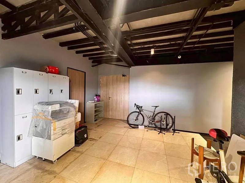 Warehouse for rent in Prawet, Bangkok - Storage room with lockers, exposed beams, and tiled floor.