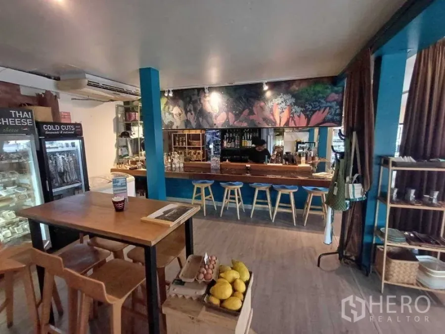 Retail Space for rent in Watthana, Bangkok - Retail cafe interior with wooden tables, a bar counter, glass-door fridges and shelving.