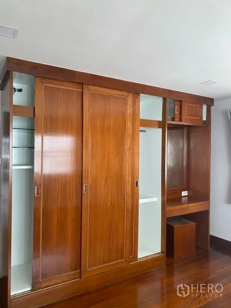 Condominium for rent in Sathon, Bangkok - Close-up of sliding wooden wardrobe with dressing nook, shelves, and storage compartments.