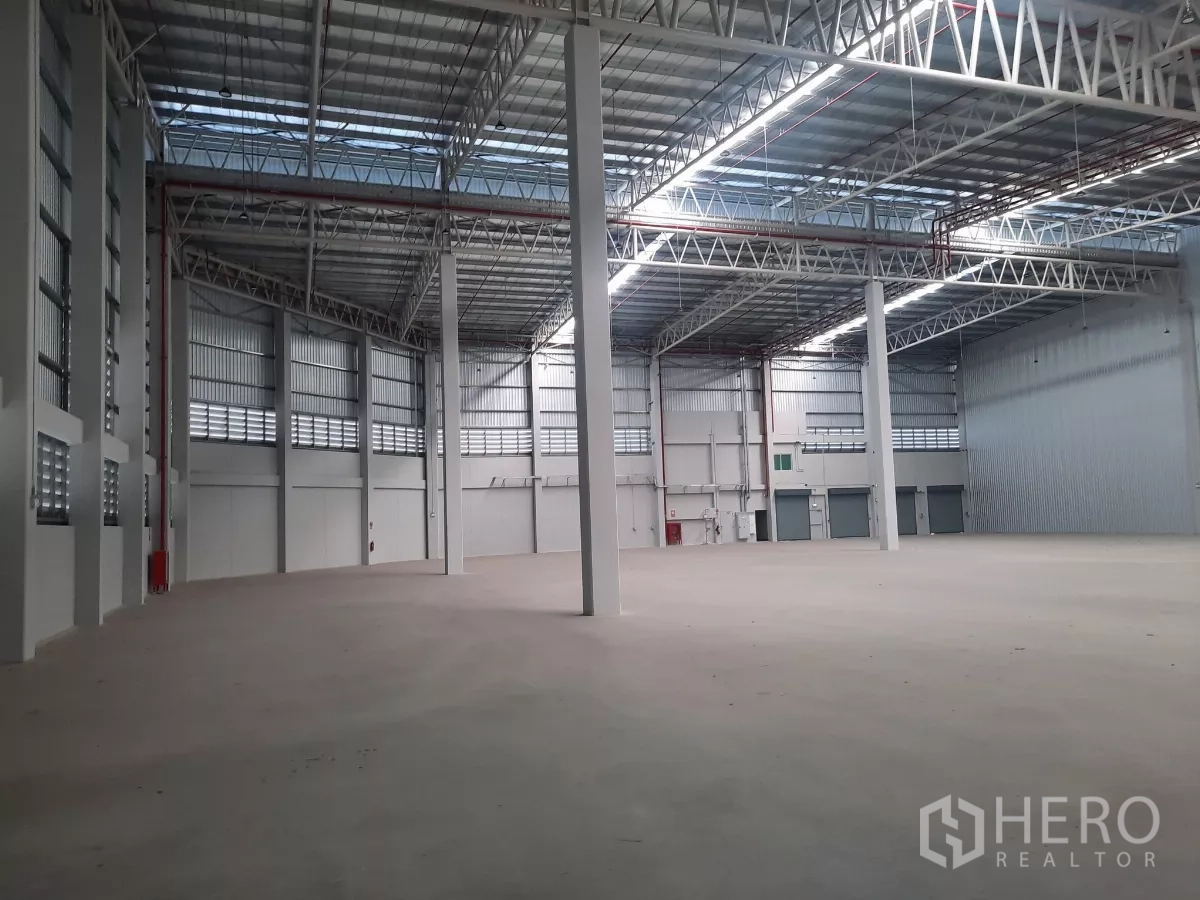 工厂 出租在Bang Lamung, Chon Buri - 高跨仓库内部，钢桁架与平整地面。