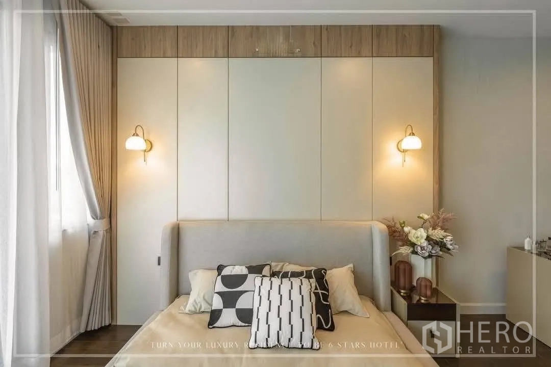 บ้านเดี่ยว for rent or sale in Suan Luang, Bangkok - ห้องนอนอบอุ่นติดโคมไฟผนังและโต๊ะข้างตกแต่ง