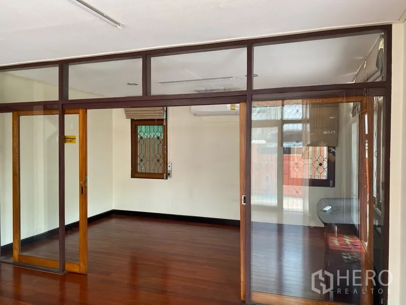独立式住宅 出租在Khlong Toei, Bangkok - 玻璃隔断的多功能房，木框推拉门与亮泽木地板。
