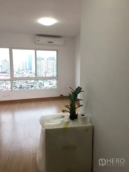 公寓 出租在Bangkok - 转角房间，木地板与大幅城市景观窗，墙挂空调。