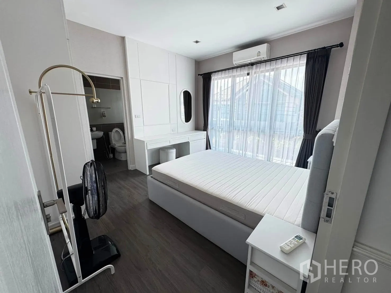 Detached House for rent in Saphan Sung, Bangkok - Bright bedroom with ensuite bathroom, sliding glass door to balcony, and air conditioner.