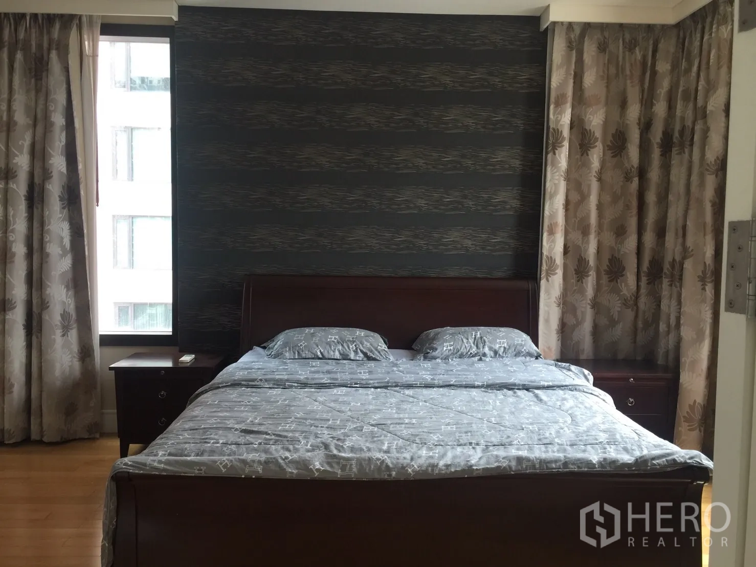 公寓 出租在Khlong Toei, Bangkok - 卧室配大床与床头柜，深色强调墙和窗帘。