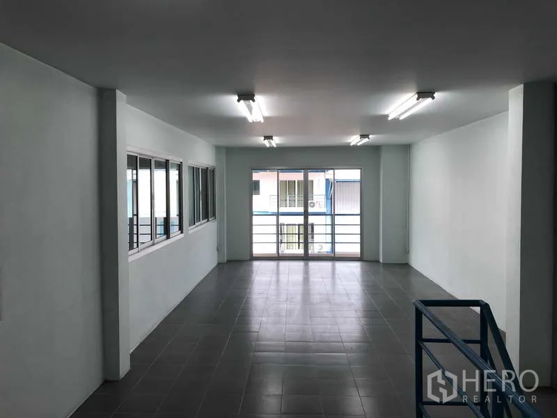 Warehouse for rent in Bang Phli, Samut Prakan - Second‑floor office space with balcony, sliding glass doors and tiled flooring.