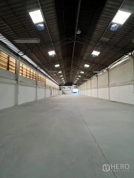 Warehouse for rent in Khlong Toei, Bangkok - Long clear-span warehouse bay with skylights and smooth concrete floor.