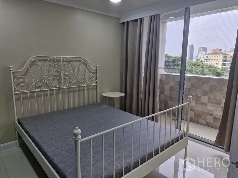 คอนโด ให้เช่าในWatthana, Bangkok - ห้องนอนเตียงเหล็กสีขาวและประตูกระจกออกระเบียงวิวเมือง